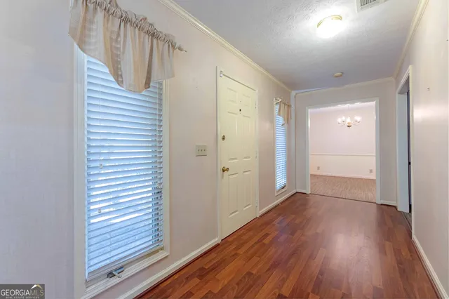 a view of a hallway with wooden floor and entryway
