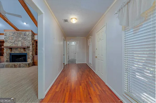 a view of a hallway with wooden floor and staircase
