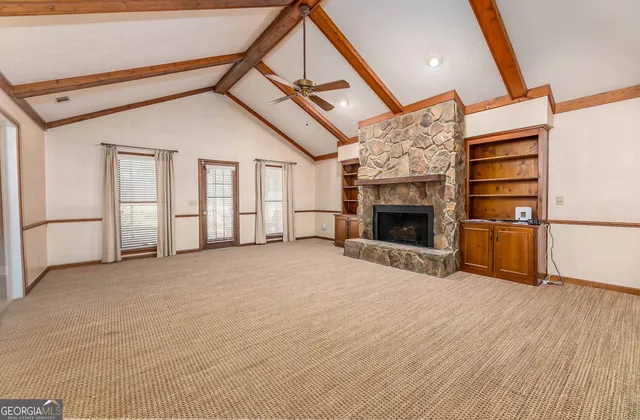 a view of empty room with fireplace and wooden floor