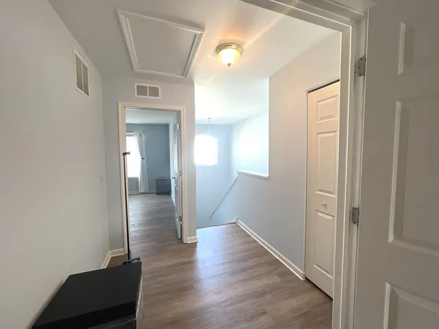 a view of a hallway with wooden floor and closet