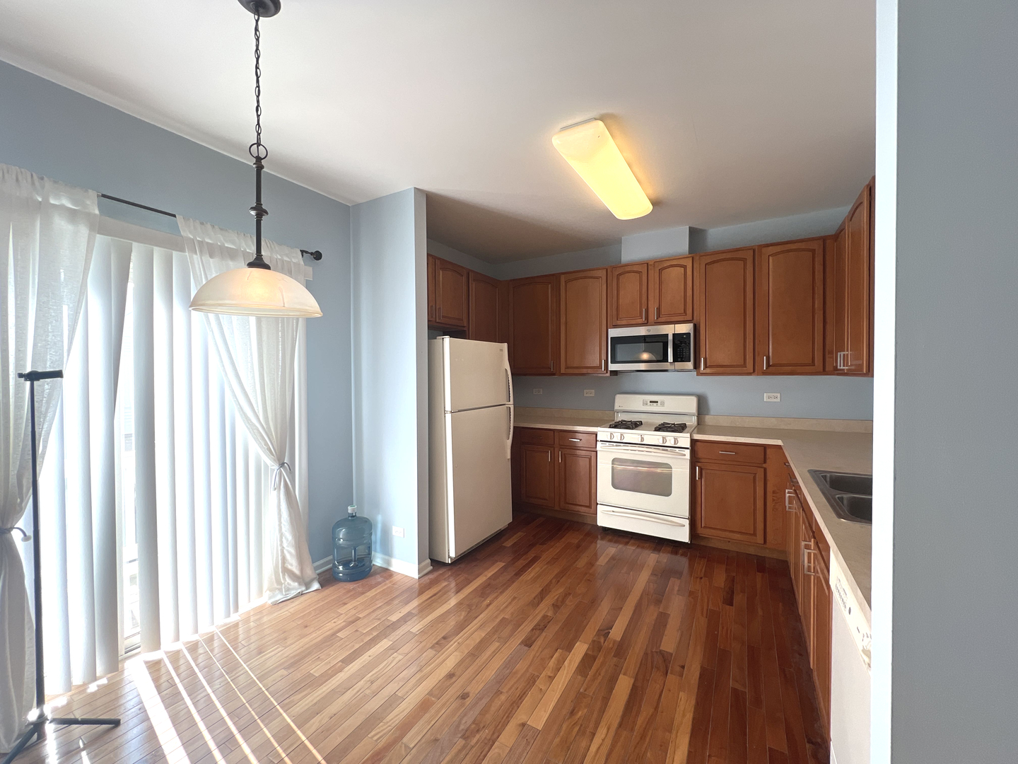 669 South Rosehall Lane, Unit 669 Round Lake, IL 60073 - Photo 4 of 17 a kitchen with granite countertop wooden floors stainless steel appliances and window
