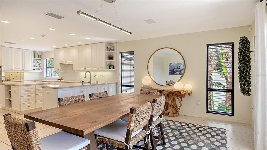 3151 Bayou Sound Longboat Key, FL 34228 - Photo 15 of 68 a dining hall with stainless steel appliances a dining table and chairs with wooden floor