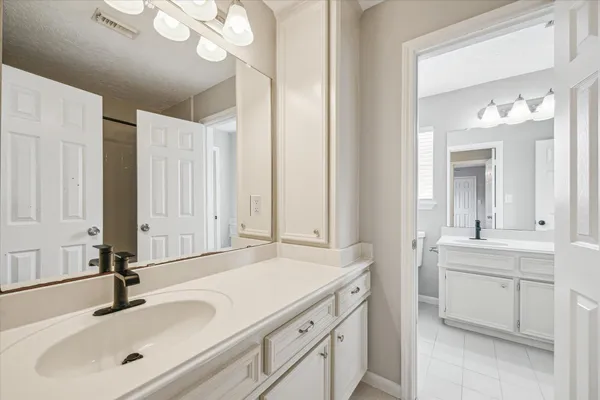 a bathroom with a shower sink vanity and mirror