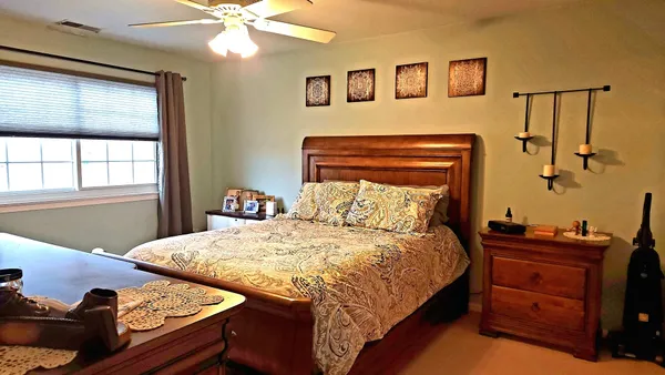 a bedroom with a bed and dresser with mirror