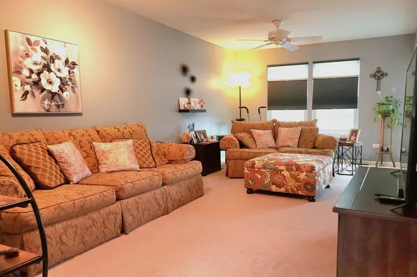 a living room with furniture a flat screen tv and a large window