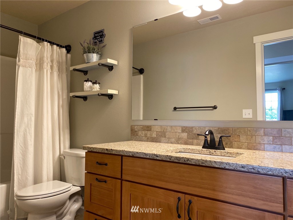 9235 179th Trail Southwest Rochester, WA 98579 - Photo 24 of 38 a bathroom with a granite countertop sink toilet and shower