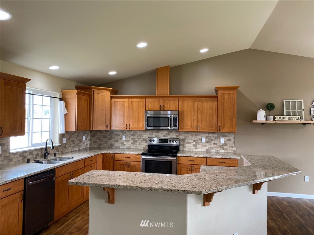 9235 179th Trail Southwest Rochester, WA 98579 - Photo 5 of 38 a kitchen with granite countertop a sink a stove and cabinets