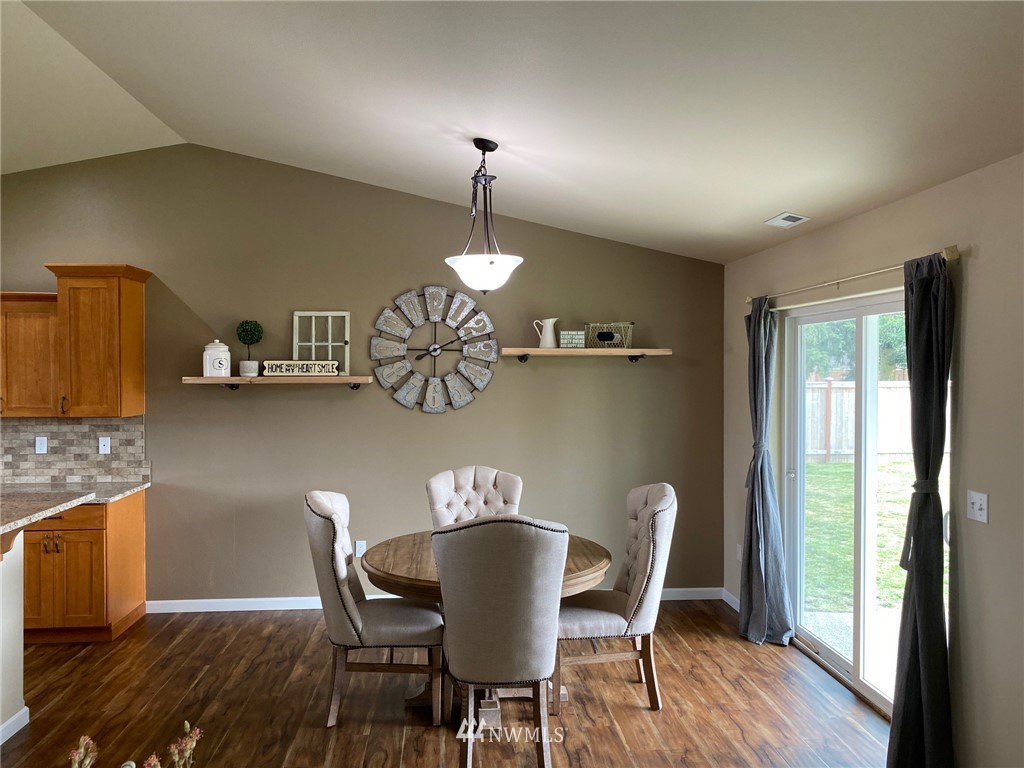 9235 179th Trail Southwest Rochester, WA 98579 - Photo 10 of 38 a view of a dining room with furniture a chandelier and wooden floor
