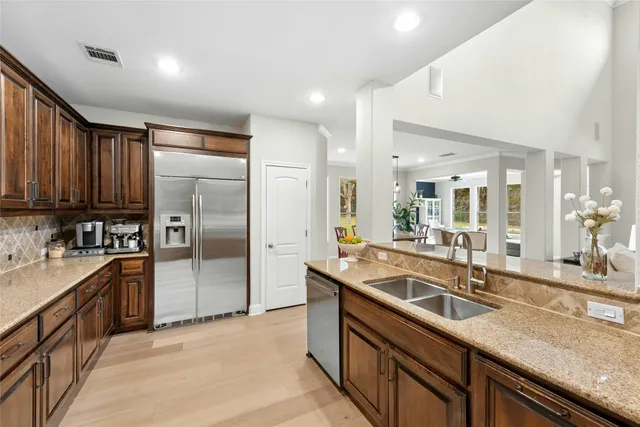 a kitchen with stainless steel appliances granite countertop a sink a stove and a refrigerator