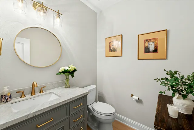 a bathroom with a granite countertop toilet a sink and a mirror