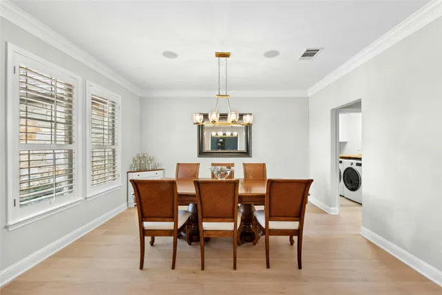 a dining room with furniture a chandelier and wooden floor