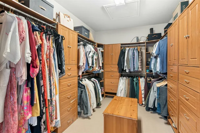 a view of walk in closet with clothes and shoes