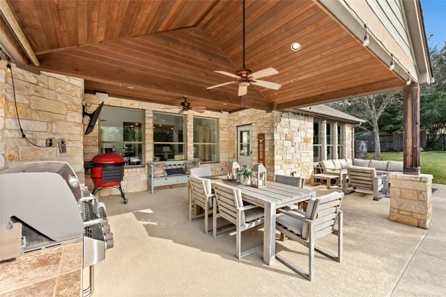 a view of a patio with table and chairs and a barbeque