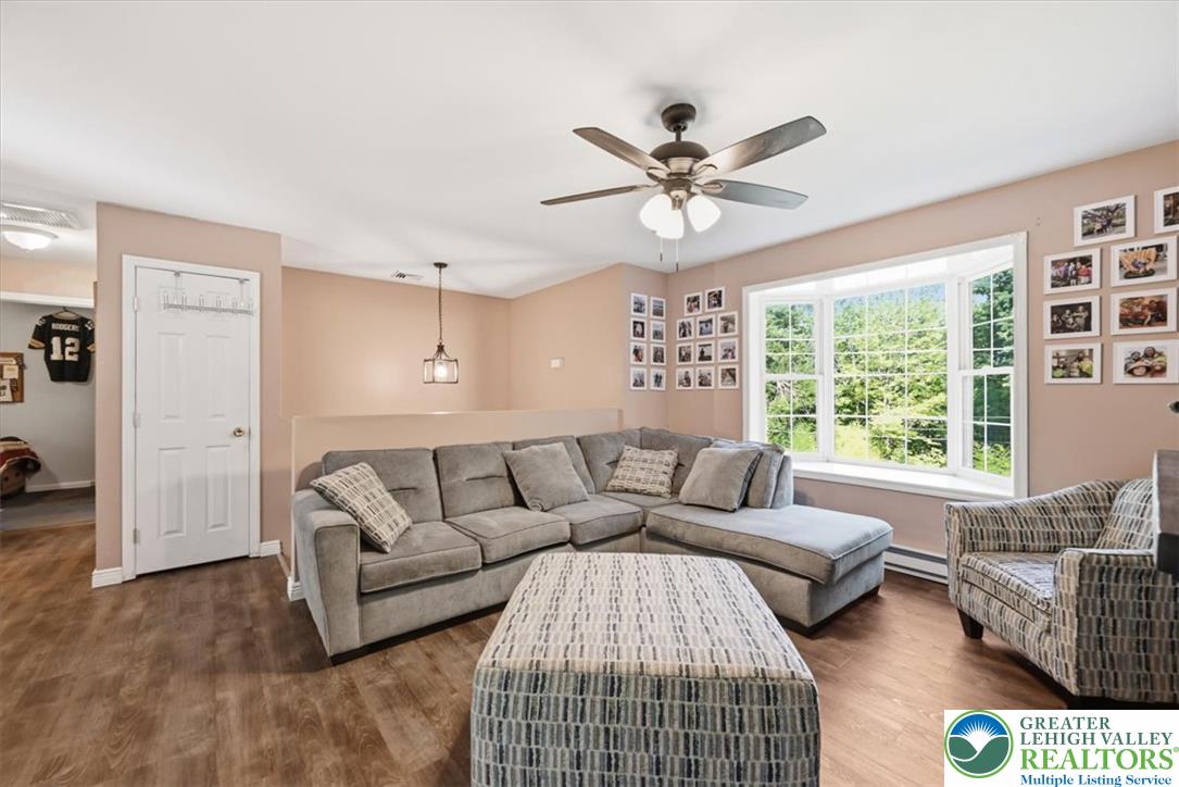 128 Chestnut Street Dingmans Ferry, PA 18328 - Photo 14 of 43 A comfortable living area with new flooring and a wide bay window framing lush outdoor views.