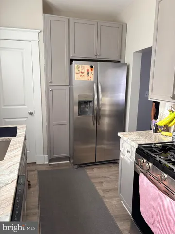 a kitchen with stainless steel appliances granite countertop a refrigerator and a stove