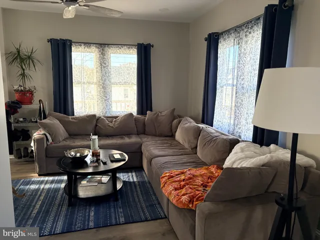 a living room with furniture a table and a large window