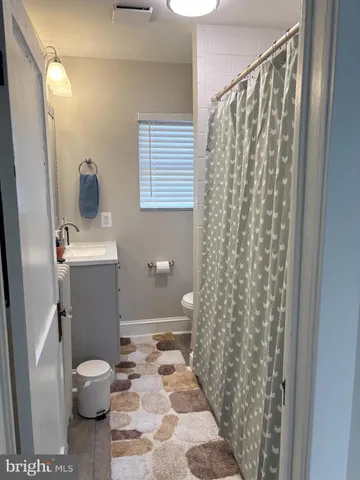 a bathroom with a toilet and a shower curtain