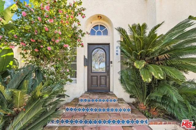a view of front door of house with potted plants