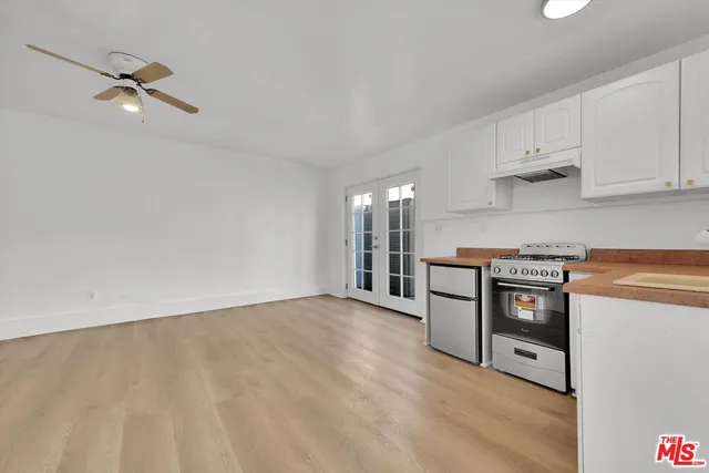 a kitchen with granite countertop white cabinets and stainless steel appliances