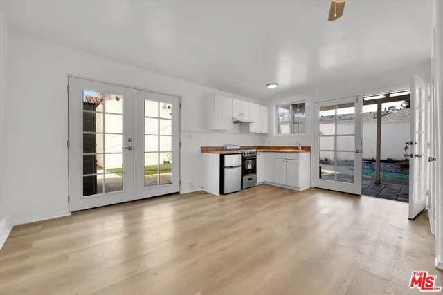 a view of a kitchen with a sink a refrigerator and a large window