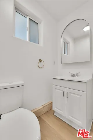 a bathroom with a sink mirror vanity and toilet