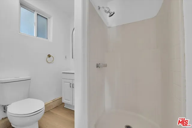 a white toilet sitting next to a shower