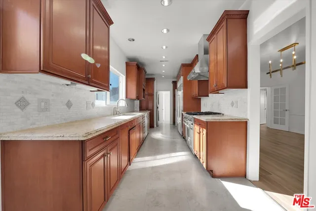 a kitchen with stainless steel appliances granite countertop a sink a stove and a refrigerator