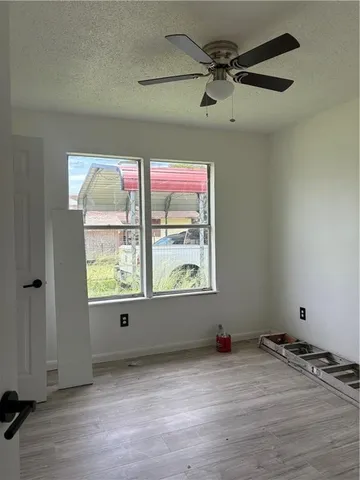 an empty room with a window and wooden floor