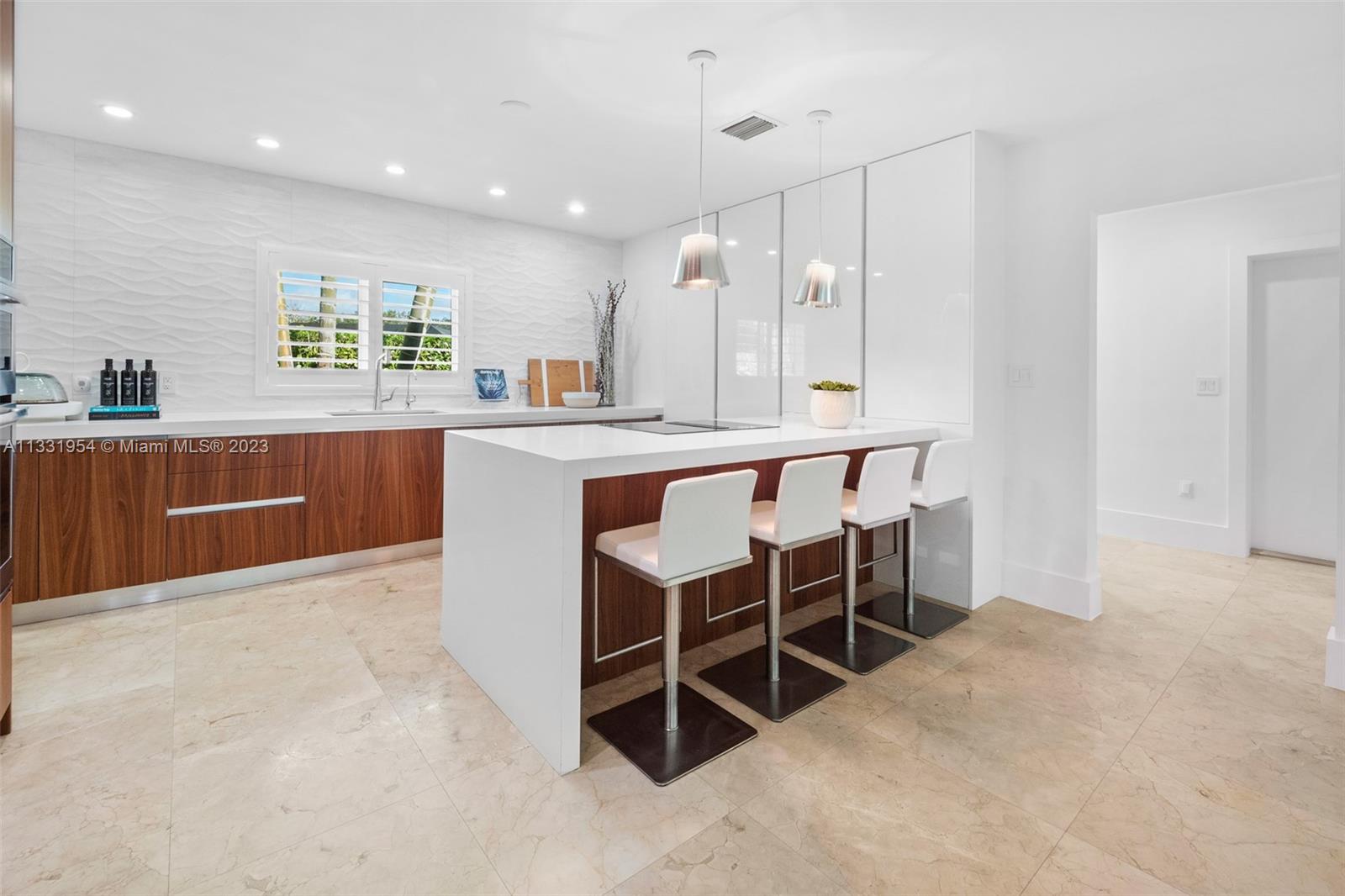 12050 Moss Ranch Road Pinecrest, FL 33156 - Photo 12 of 45 a large kitchen with cabinets chairs and chairs