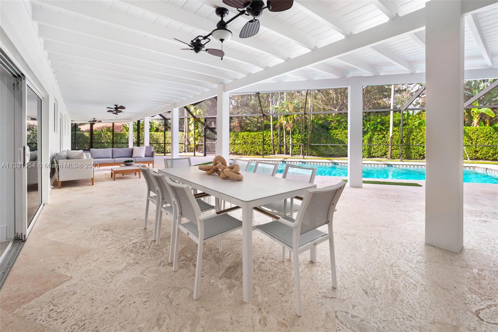 12050 Moss Ranch Road Pinecrest, FL 33156 - Photo 14 of 45 a view of a dining room with furniture large windows and wooden floor