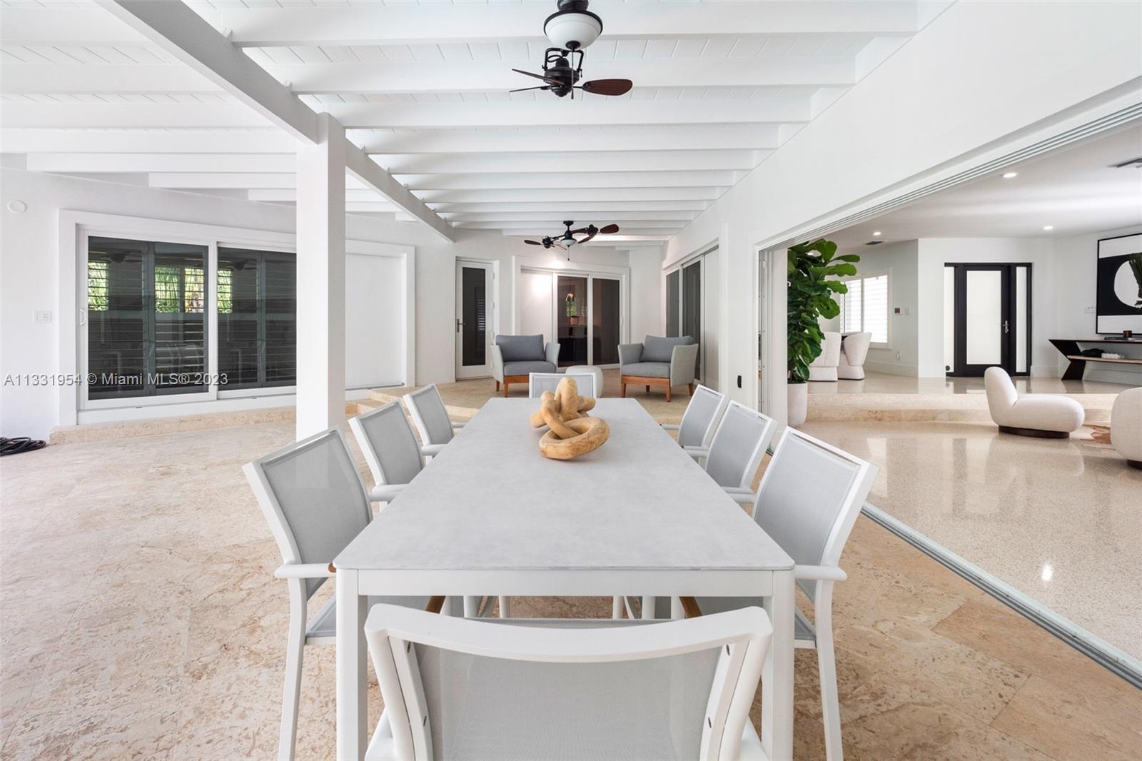 12050 Moss Ranch Road Pinecrest, FL 33156 - Photo 15 of 45 a view of a dining room with furniture wooden floor and chandelier
