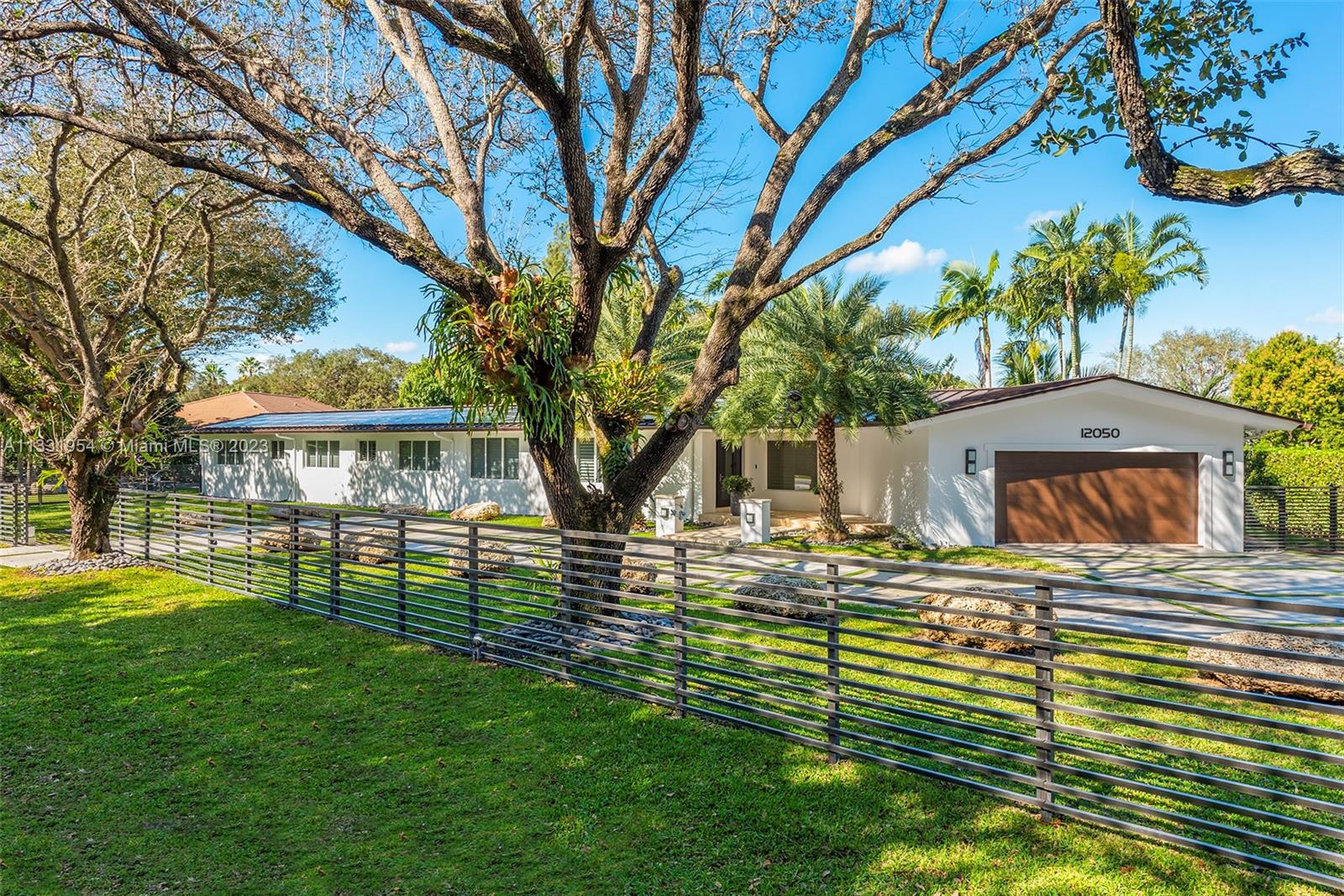 12050 Moss Ranch Road Pinecrest, FL 33156 - Photo 2 of 45 a front view of a house with a yard