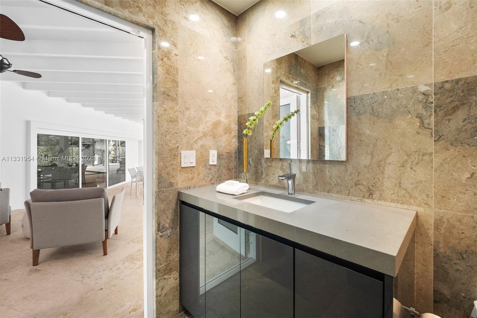 12050 Moss Ranch Road Pinecrest, FL 33156 - Photo 34 of 45 a en suite bathroom with a sink and a mirror