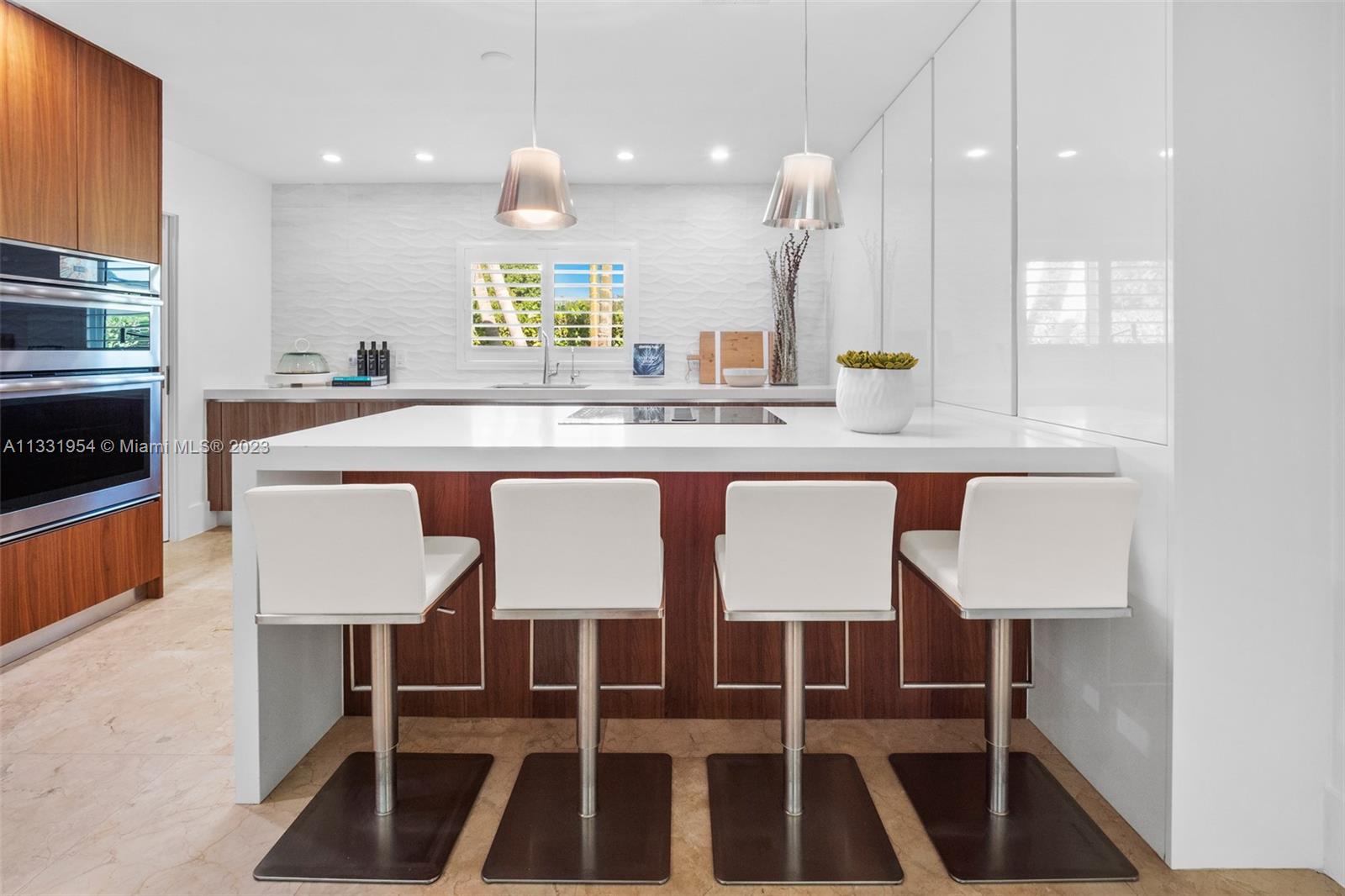 12050 Moss Ranch Road Pinecrest, FL 33156 - Photo 10 of 45 a kitchen with a dining table chairs and white cabinets