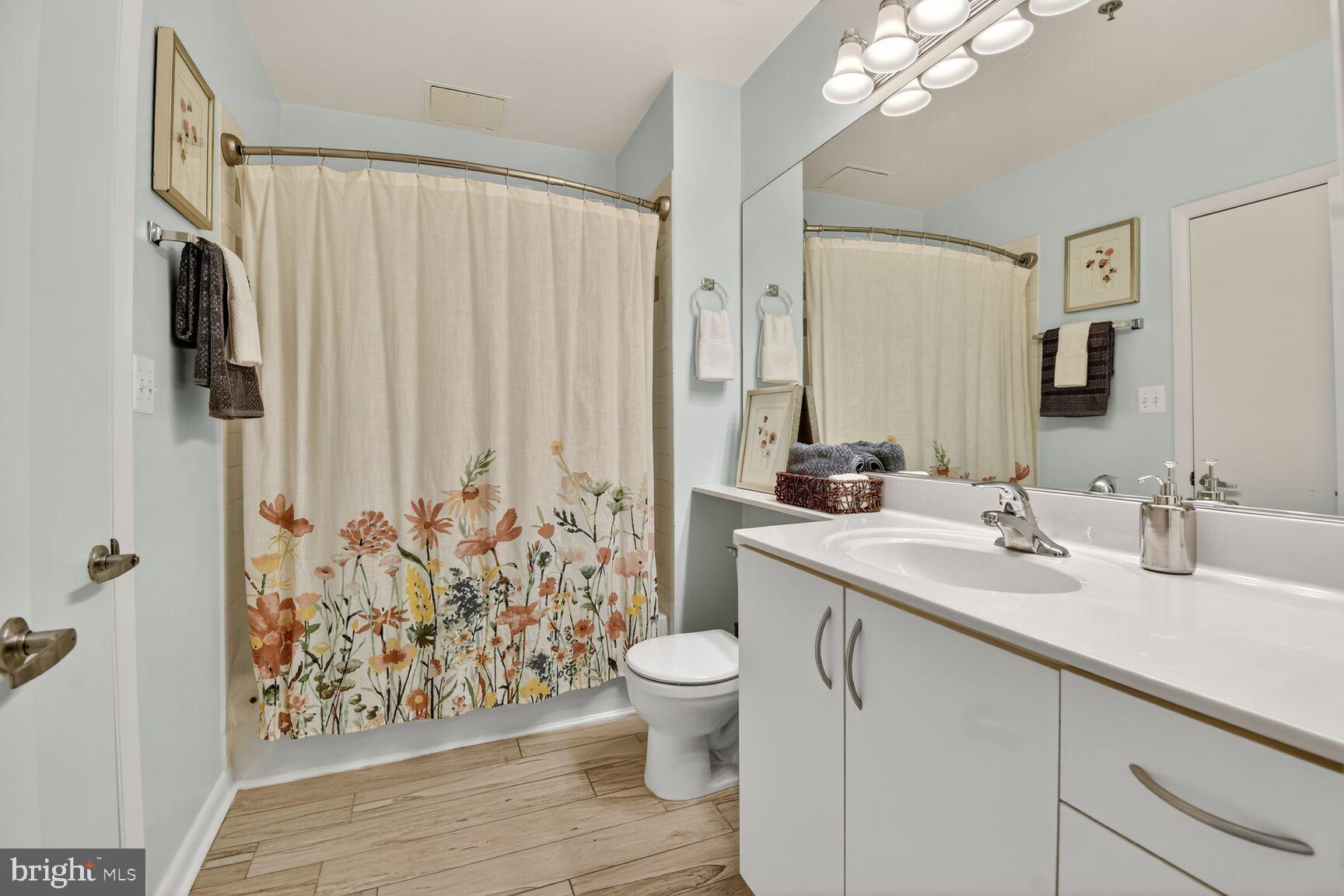 1300 N Street Northwest, Unit 214 Washington, DC 20005 - Photo 16 of 41 a bathroom with a granite countertop sink a toilet and a large mirror