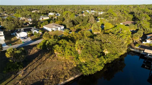 an aerial view of residential houses with outdoor space and trees