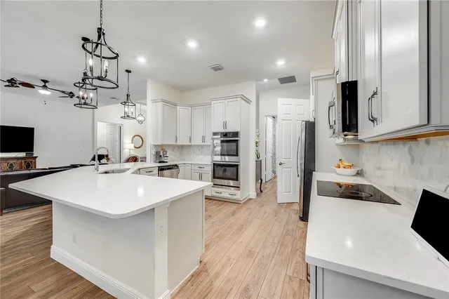 a kitchen with a center island appliances and cabinets