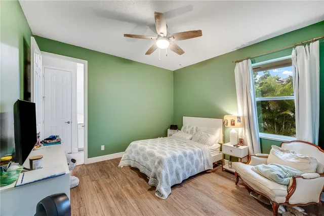 a bedroom with a bed window and a flat screen tv