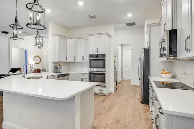 a kitchen with a sink a counter top space stainless steel appliances and cabinets