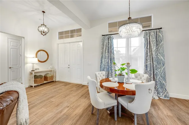 a view of a dining room with furniture a chandelier and wooden floor
