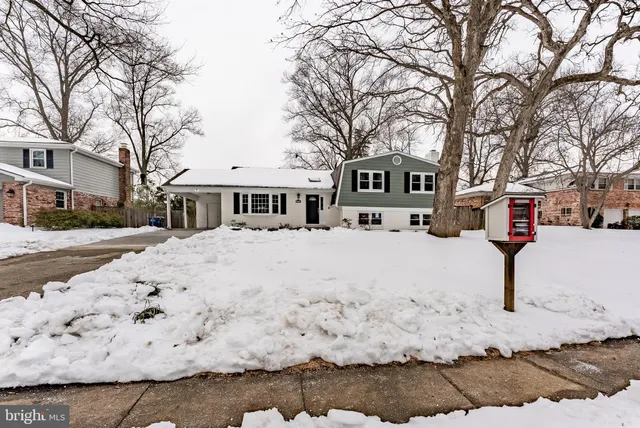 a front view of a house with a yard covered in snow