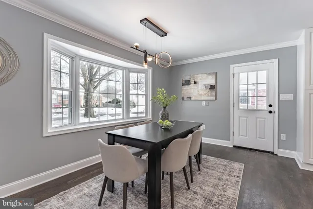 a dining room with furniture a chandelier and wooden floor