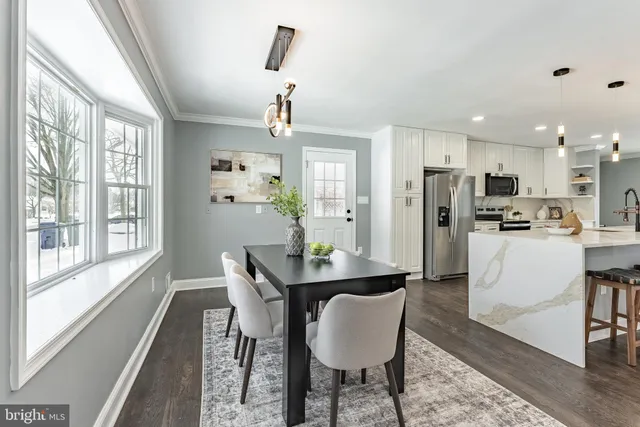 a kitchen with stainless steel appliances granite countertop a refrigerator a sink dishwasher and white cabinets with wooden floor