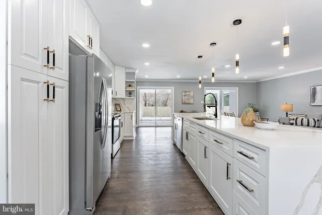a large kitchen with stainless steel appliances lots of counter space and wooden floor