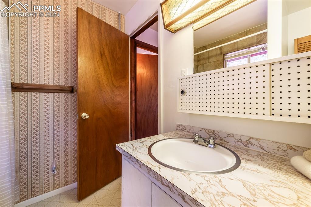441 Westcliffe Drive Rye, CO 81069 - Photo 18 of 29 a bathroom with a granite countertop sink and a mirror