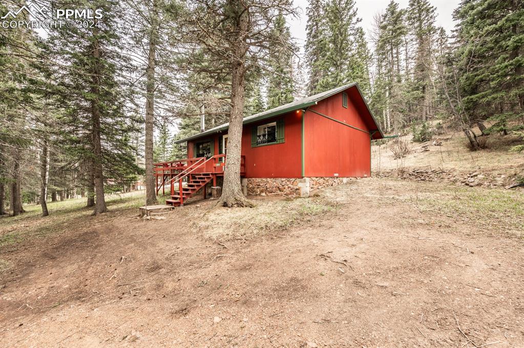 441 Westcliffe Drive Rye, CO 81069 - Photo 3 of 29 a backyard of a house with a large tree and wooden fence