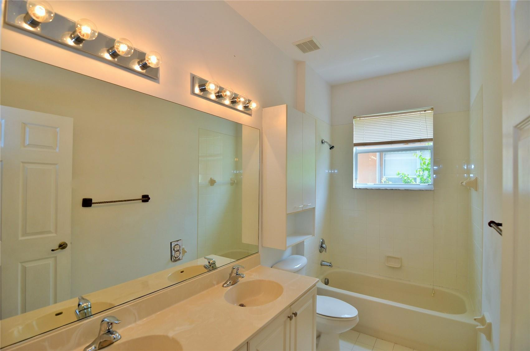 5455 Southwest 191st Terrace Miramar, FL 33029 - Photo 16 of 20 a bathroom with a granite countertop sink a toilet and shower
