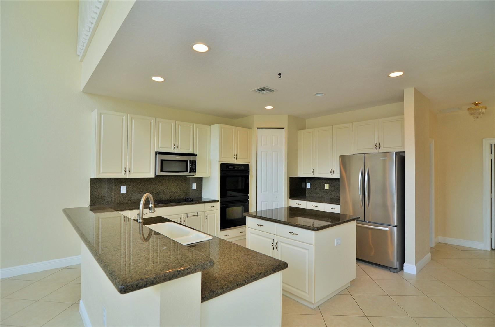 5455 Southwest 191st Terrace Miramar, FL 33029 - Photo 9 of 20 a kitchen with kitchen island a refrigerator stove microwave and sink