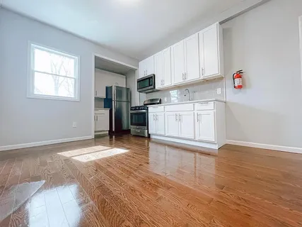 a kitchen with granite countertop a stove a sink and a refrigerator