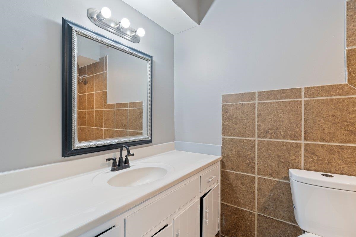 3384 South Mendenhall Road Memphis, TN 38115 - Photo 12 of 22 Bathroom with tile walls, toilet, and vanity